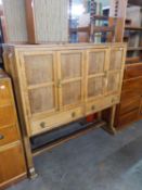 ARTS AND CRAFTS STYLE OAK CABINET, ENCLOSED BY TWO PAIRS OF FRAMED PANEL DOORS, WITH ROW OF TWO