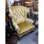 A GOOD QUALITY BUTTON BACK UPHOLSTERED ARMCHAIR, HAVING CARVED CLAW AND BALL LEGS TO THE FRONT (A.