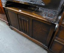 AN OAK JACOBEAN STYLE BLANKET BOX, WITH THREE PANEL FRONT WITH LINEN FOLD CARVING, ON BUN FEET