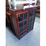 A REPRODUCTION SMALL BOOKCASE WITH TWO GLAZED DOORS