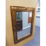 A RECTANGULAR BEVELLED EDGE WALL MIRROR, IN TEXTURED GILT FRAME, WITH EMBOSSED SHAPES, 3'8" HIGH,