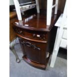 A SMALL LATE VICTORIAN MAHOGANY BOW-FRONT CABINET, WITH A DRAWER AND CUPBOARD UNDERNEATH, ON