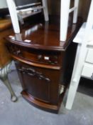 A SMALL LATE VICTORIAN MAHOGANY BOW-FRONT CABINET, WITH A DRAWER AND CUPBOARD UNDERNEATH, ON