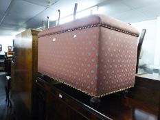 AN OTTOMAN BOX, UPHOLSTERED AND COVERED IN PINK AND GREY DIAPER PATTERN FABRIC