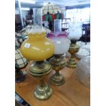 TWO CLOSELY MATCHED BRASS OIL LAMPS, WITH GLASS SHADES AND FUNNELS, 22" HIGH AND SLIGHTLY SMALLER (