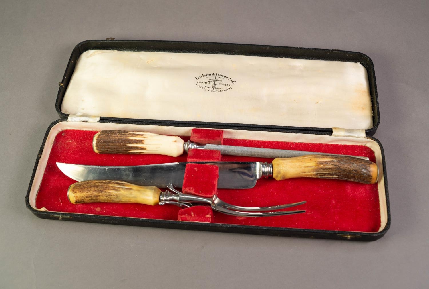 CASED THREE PIECE CARVING SET WITH HORN HANDLES, in red plush lined case marked for Latham & Owen