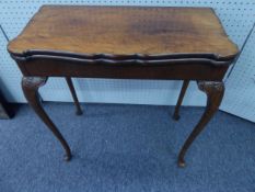 EARLY TWENTIETH CENTURY FIGURED AND CARVED WALNUT CARD TABLE IN THE QUEEN ANNE TASTE, the shaped