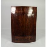 NINETEENTH CENTURY FIGURED MAHOGANY BOW FRONTED CORNER CUPBOARD, with flame cut twin panelled