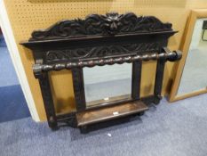 A CARVED DARK STAINED HALL WALL HANGING, WITH MIRROR AND SHELF, HAVING LIONS HEAD CARVING TO CORNICE