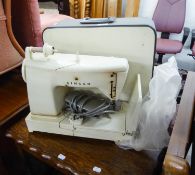 A SINGER ELECTRIC SEWING MACHINE WITH FOOT CONTROL AND ATTACHMENTS