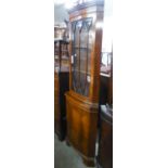 A MODERN REPRODUCTION MAHOGANY BOW-FRONT STANDING CORNER CUPBOARD