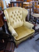 A GOOD QUALITY BUTTON BACK UPHOLSTERED ARMCHAIR, HAVING CARVED CLAW AND BALL LEGS TO THE FRONT (A.