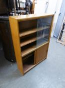 A LIGHT MAHOGANY SMALL BOOKCASE WITH TWO GLASS SLIDING DOORS, ENCLOSING TWO SHELVES, CUPBOARD