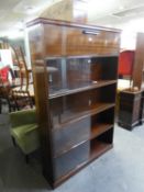 AN INTER-WAR YEARS MAHOGANY BOOKCASE WITH SLIDING DOORS AND ENCLOSED UPPER SECTION