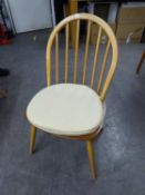 A SET OF FOUR ERCOL BLONDE ELM AND BEECH WINDSOR HOOP BACK SINGLE CHAIRS WITH PANEL SEATS AND