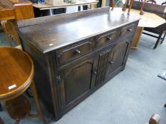 AN OAK SIDEBOARD, HAVING THREE DRAWERS OVER TWO CUPBOARDS