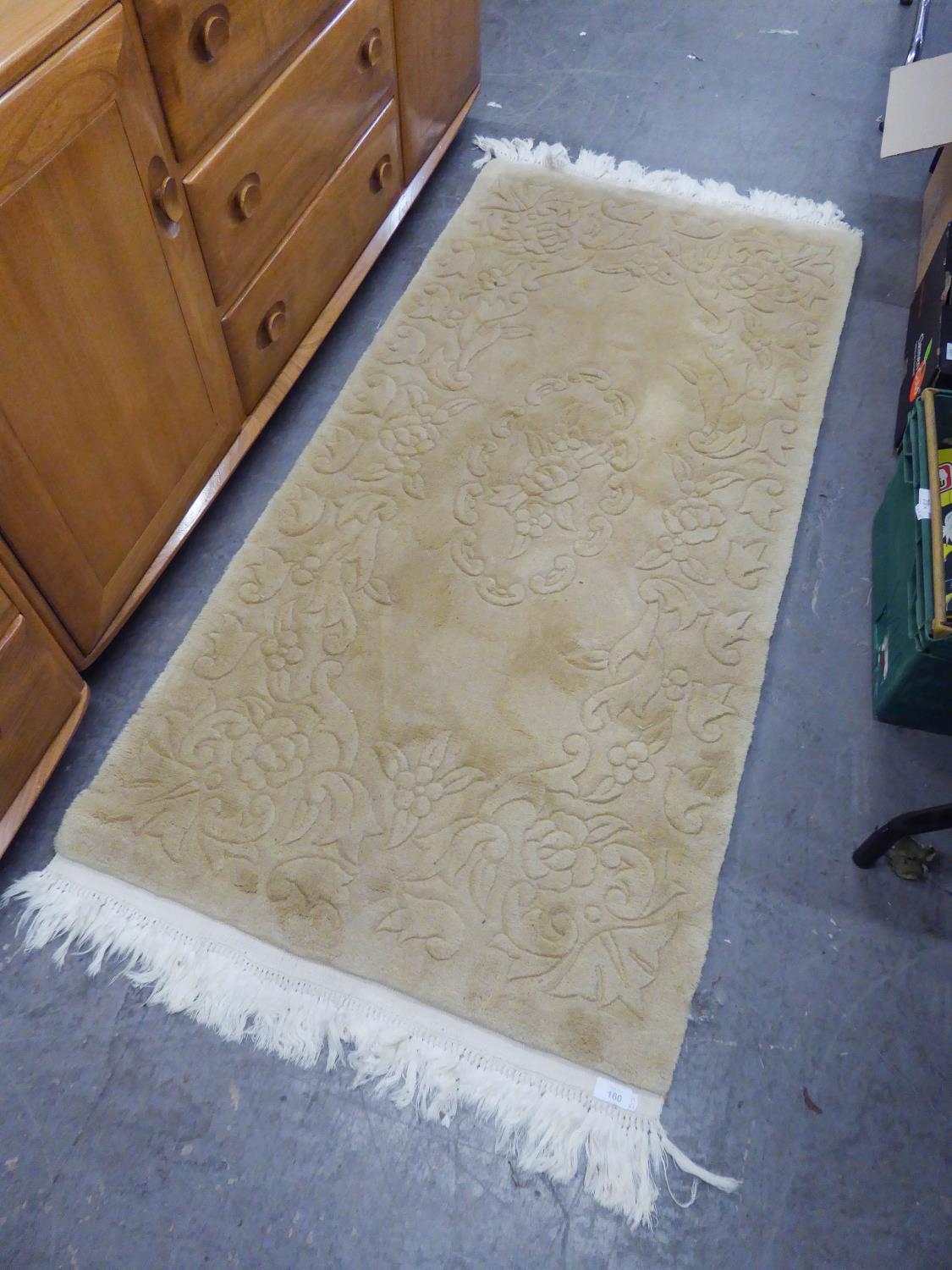 A WASHED CHINESE EMBOSSED CREAM HEARTH RUG