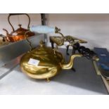 AN ANTIQUE BRASS TRIVET WITH TURNED WOOD HANDLE AND A BRASS KETTLE WITH BLUE GLASS HANDLE