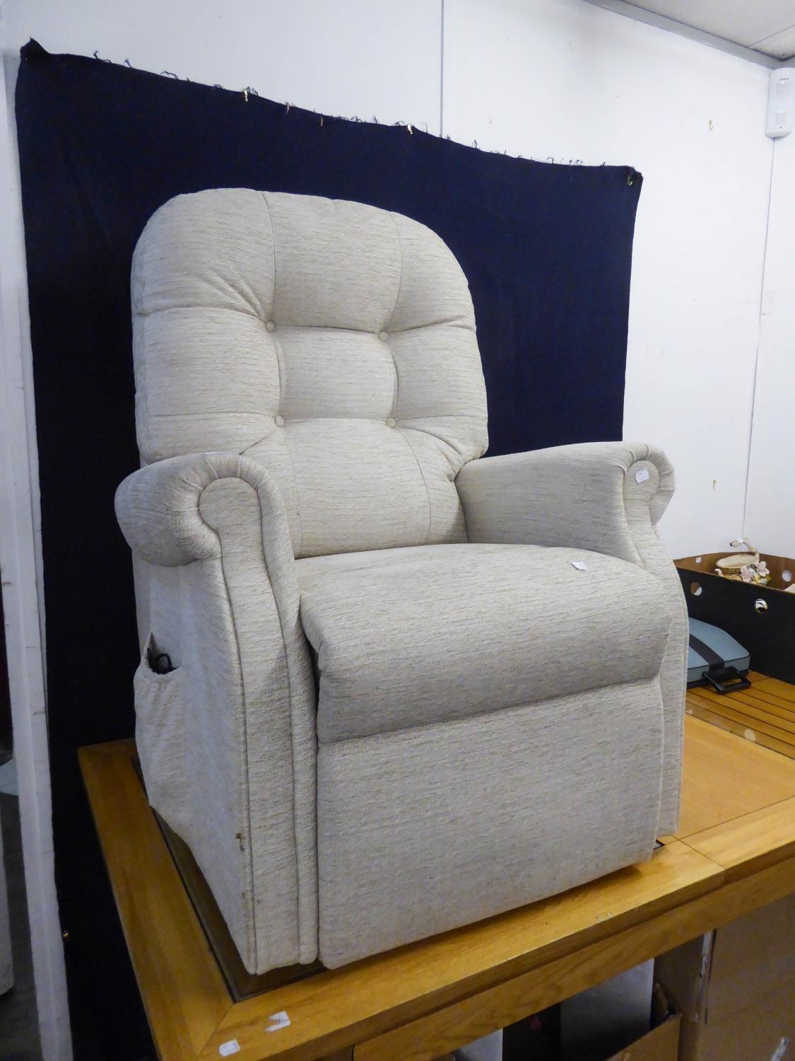 AN ELECTRICALLY ADJUSTABLE LOUNGE ARMCHAIR, COVERED IN BEIGE WOVEN FABRIC