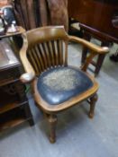 AN EARLY 20TH CENTURY OAK TUB SHAPED OFFICE ARMCHAIR, ON TURNED TAPERING FRONT SUPPORTS, WITH