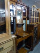 AN EARLY 20TH CENTURY CARVED OAK HALLSTAND, THE HIGH BACK WITH MIRROR AND SHELF, OVER A GLOVE BOX,