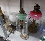AN ORNATE PIERCED BRASS VICTORIAN OIL LAMP, WITH PINK GLASS RESERVOIR AND GLASS FUNNEL, A SIMILAR