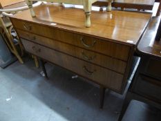 A 1960's/70's TEAK THREE DRAWER DRESSING TABLE, WITH SINGLE OBLONG MIRROR, RAISED ON TURNED SUPPORTS