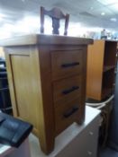 A MODERN LIGHT OAK BEDSIDE CHEST OF THREE DRAWERS WITH METAL BAR HANDLES, AND A TEAK EFFECT TWO TIER