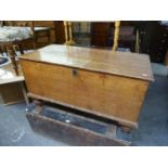 AN ANTIQUE PINE BEDDING BOX, RAISED ON SHORT BULBOUS SUPPORTS