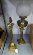 A BRASS CORINTHIAN COLUMN OIL LAMP WITH OPAQUE GLASS GLOBULAR SHADE AND GLASS FUNNEL AND A SIMILAR