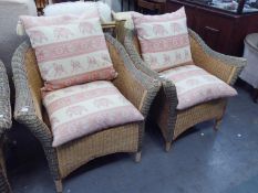 A PAIR OF HIGH BACKED LOOM TUB SHAPED ARMCHAIRS, WITH LOOSE CUSHIONS