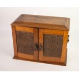 CIRCA 1920s CARVED OAK TWO DOOR SMOKER'S CABINET with hinge opening top, later fitted with four