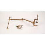 ORNATE CAST GILT BRASS PIVOTING TWO ARM BRACKET supporting two one end a four tine toasting fork,