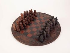 A TWENTIETH CENTURY AFRICAN CIRCULAR CARVED AND CHEQUERED WOODEN CHESS BOARD with dark and lighter