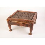 AN EARLY TWENTIETH CENTURY INDIAN SQUARE HARDWOOD STOOL, THE FRAMED PLANK TOP WITH AN ALL OVER BLIND