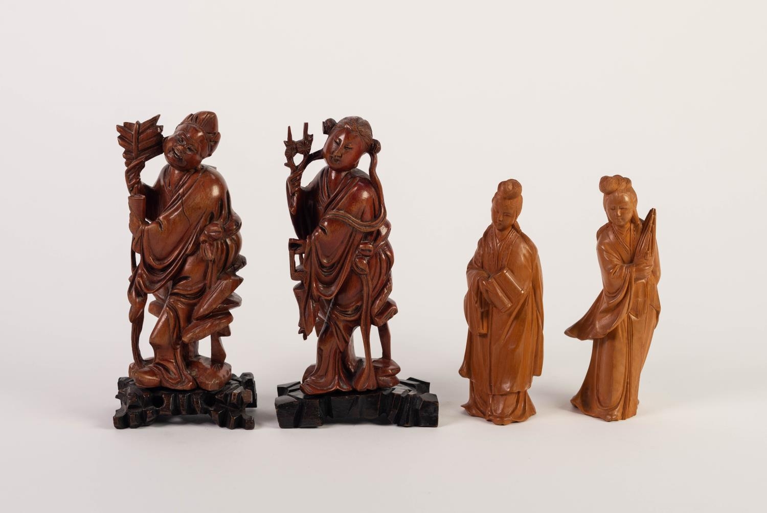 PAIR OF CHINESE CARVED REDWOOD FIGURES, each modelled standing, wearing flowing robes and carrying