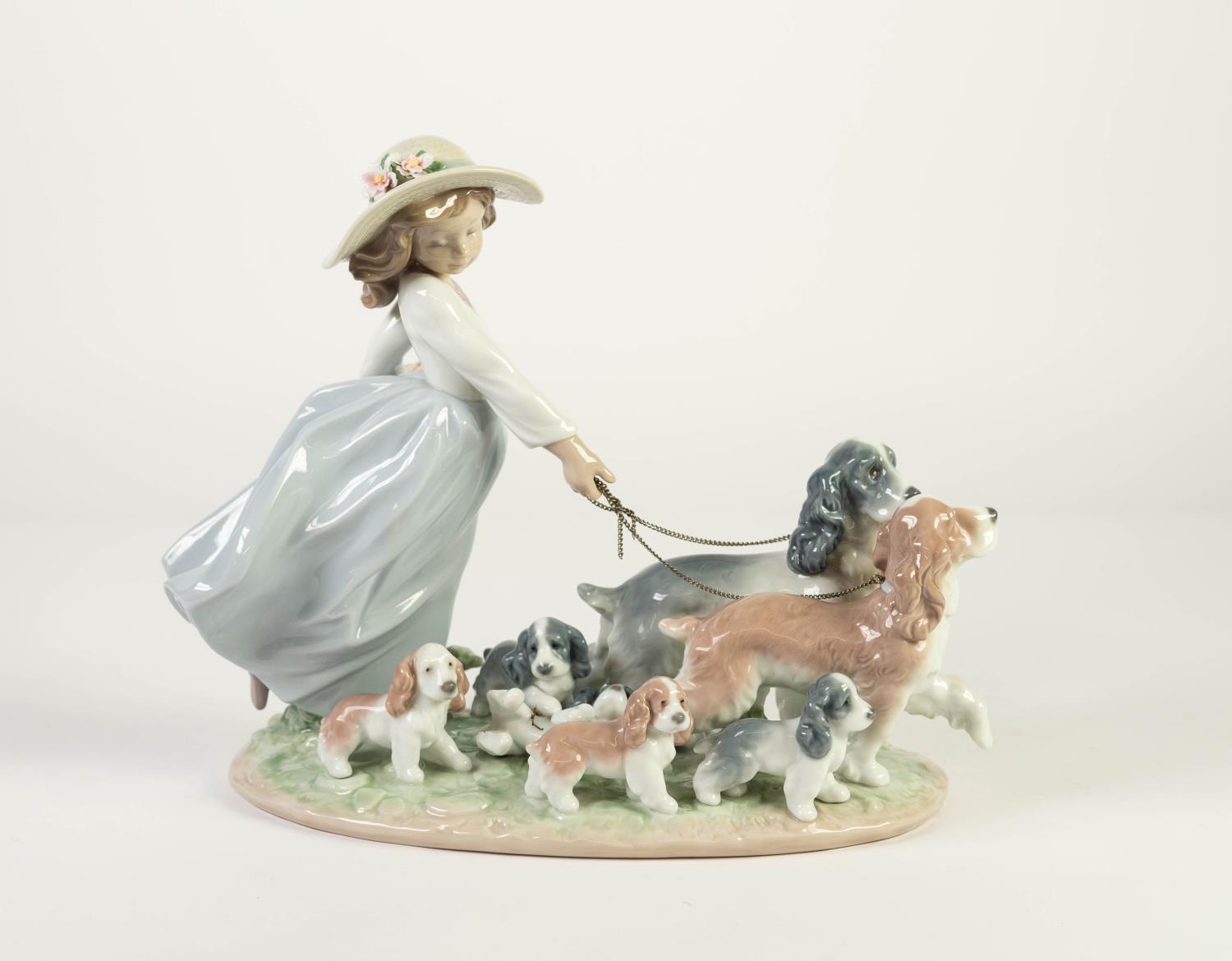LLADRO PORCELAIN MODEL OF A GIRL walking two dogs and a string of five puppies, model number 6784,