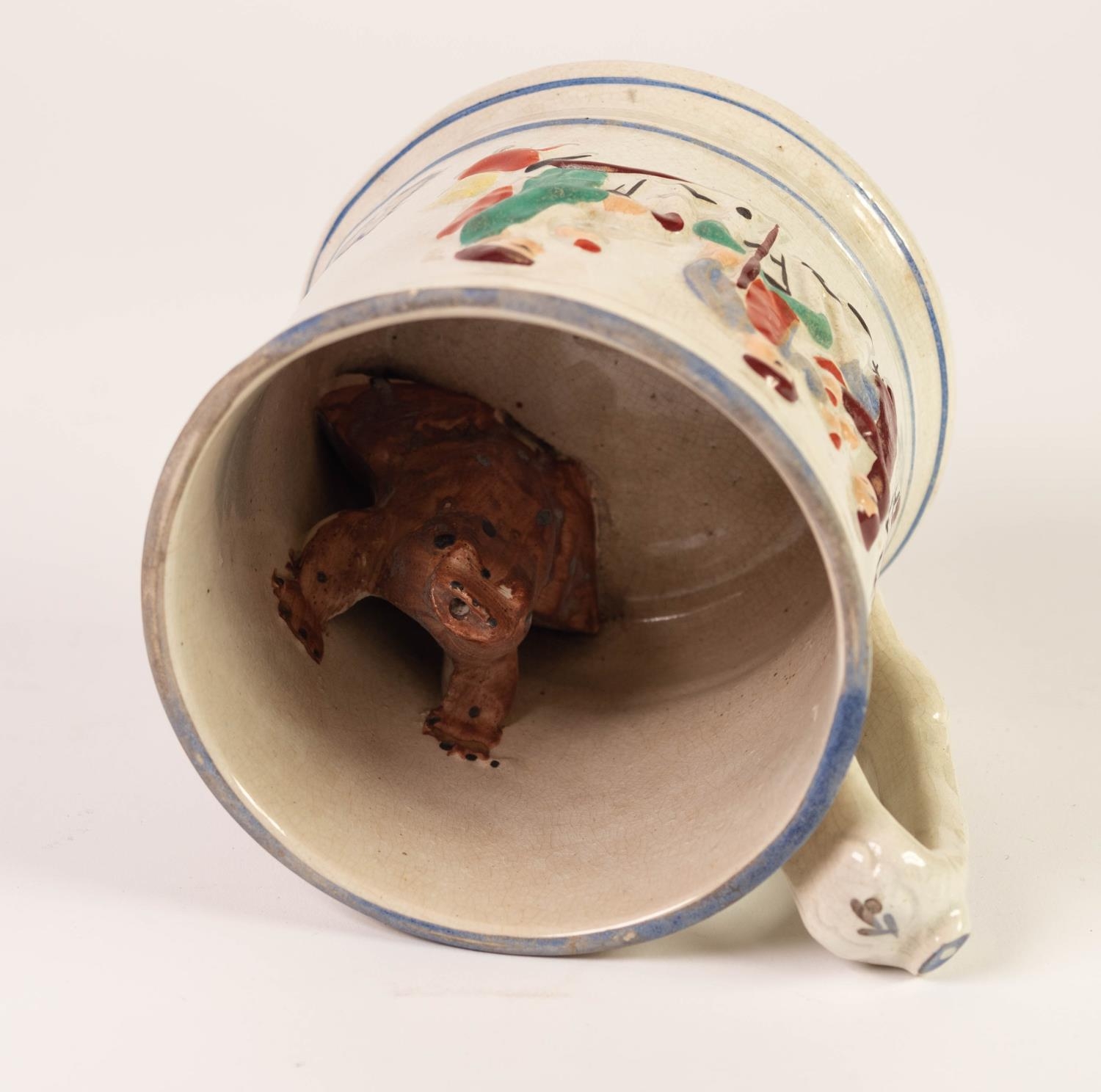 19th CENTURY POTTERY FROG MUG, moulded in bas relief with topers picked out in enamels, 5in (13cm) - Image 3 of 3