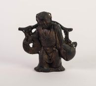 CHINESE BRONZE COLOURED CAST METAL FIGURE, modelled as a street vendor carrying a large persimmon