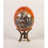 ORANGE LUSTRE GLAZED OSTRICH EGG, decorated with African wild animals, 6 ½? (16.5cm) high, on a gilt