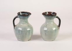 PAIR OF 1960s NIGERIAN STUDIO POTTERY JUGS with pouring lips and stopper covers, the red earthenware