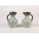 PAIR OF 1960s NIGERIAN STUDIO POTTERY JUGS with pouring lips and stopper covers, the red earthenware