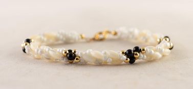 GOLD COLOUR METAL AND WHITE BEAD BRACELET with four spacers formed of black and gold colour metal