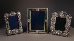 THREE SILVER FRONTED PHOTOGRAPH FRAMES WITH EASEL SUPPORTS, one embossed with cherubic faces and