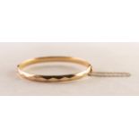 9ct GOLD AND METAL CORE HINGE OPENING BANGLE with faceted decoration and safety chain