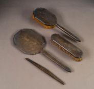 THREE PIECE ENGINE TURNED SILVER BACKED DRESSING TABLE HAND MIRROR AND BRUSH SET, and the MATCHING