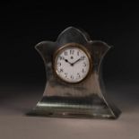 GEORGE V ENGINE TURNED SILVER CASED SMALL MANTLE OR DRESSING TABLE CLOCK, with trefoil top and