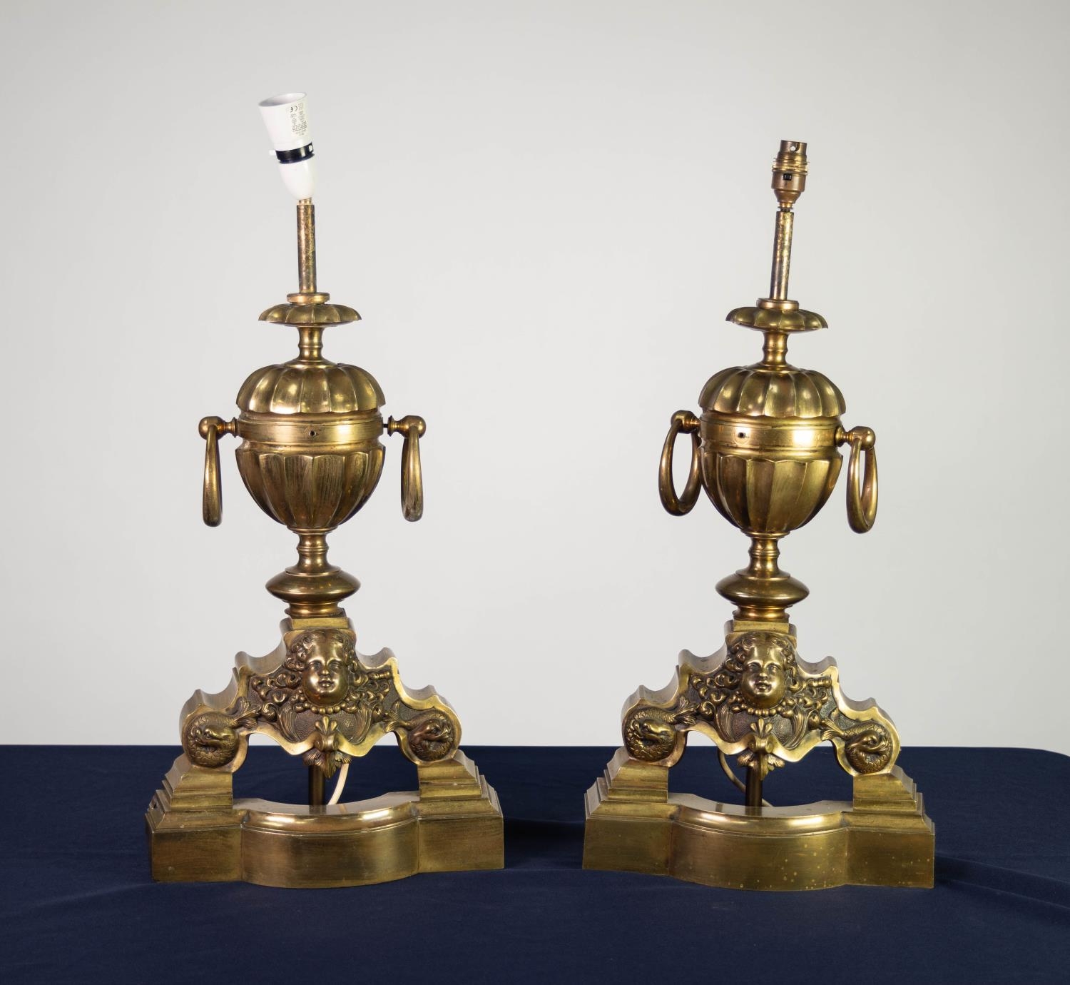 PAIR OF BRONZE CHENET PATTERN TABLE LAMPS, each with central two handled urn, above a mask capped