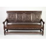 NINETEENTH CENTURY CARVED OAK SETTLE, the four panel back carved with stylised masks and Pine cone
