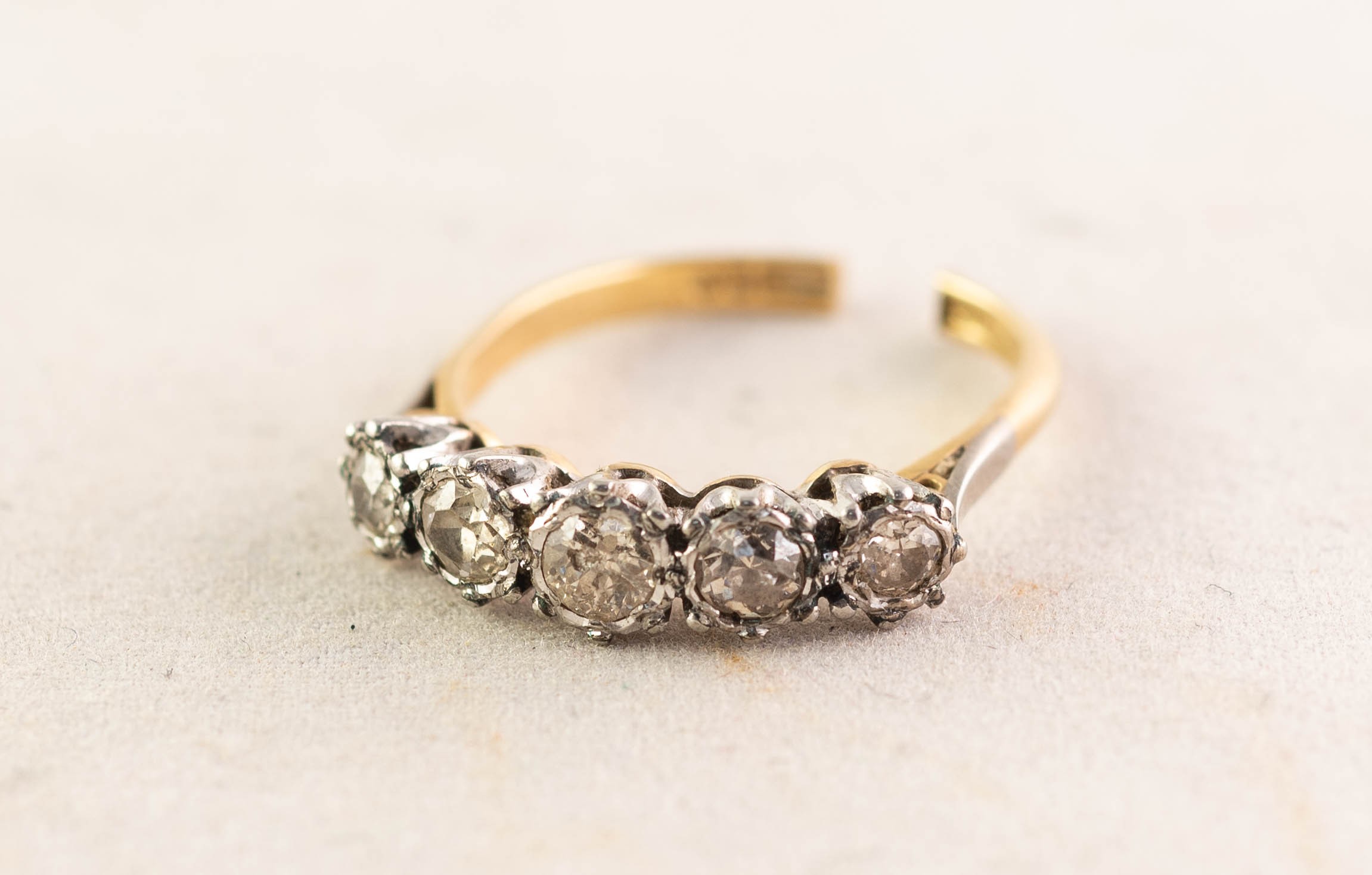 18ct GOLD AND PLATINUM RING, with five old cut diamonds graduating from the centre in claw and